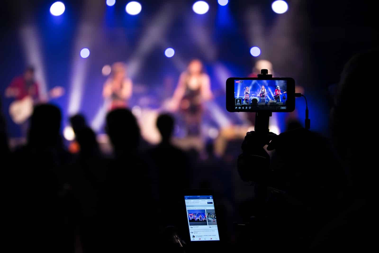 people taking videos during concert